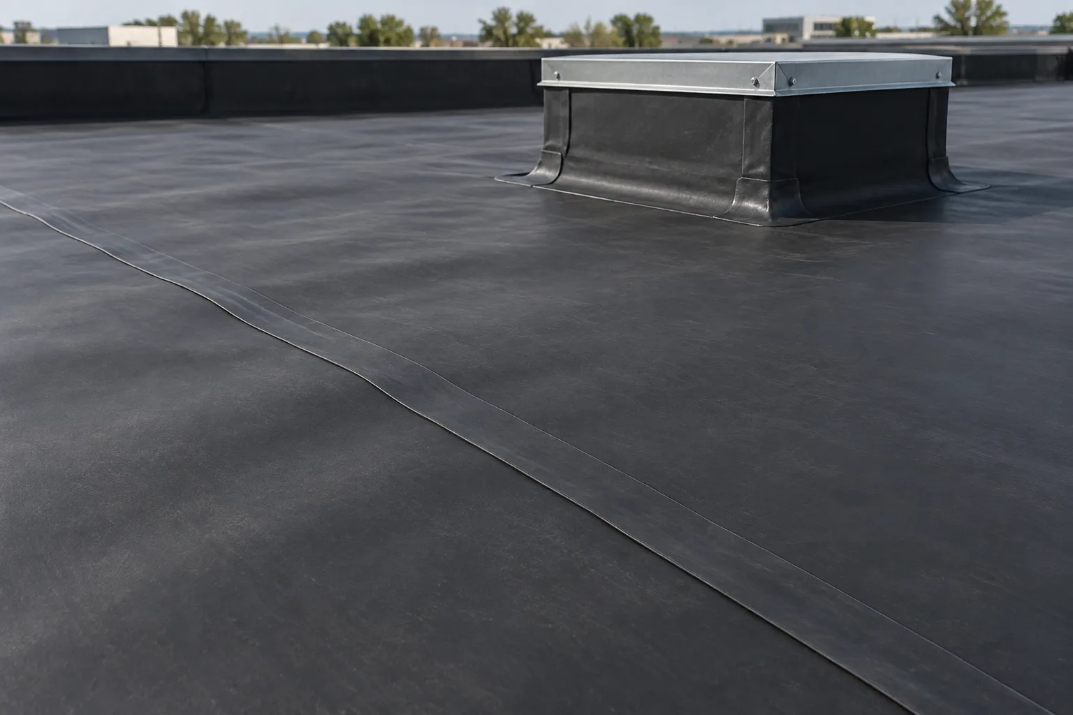 Black rubber-membrane roofing with an overlap seam and curb flashing